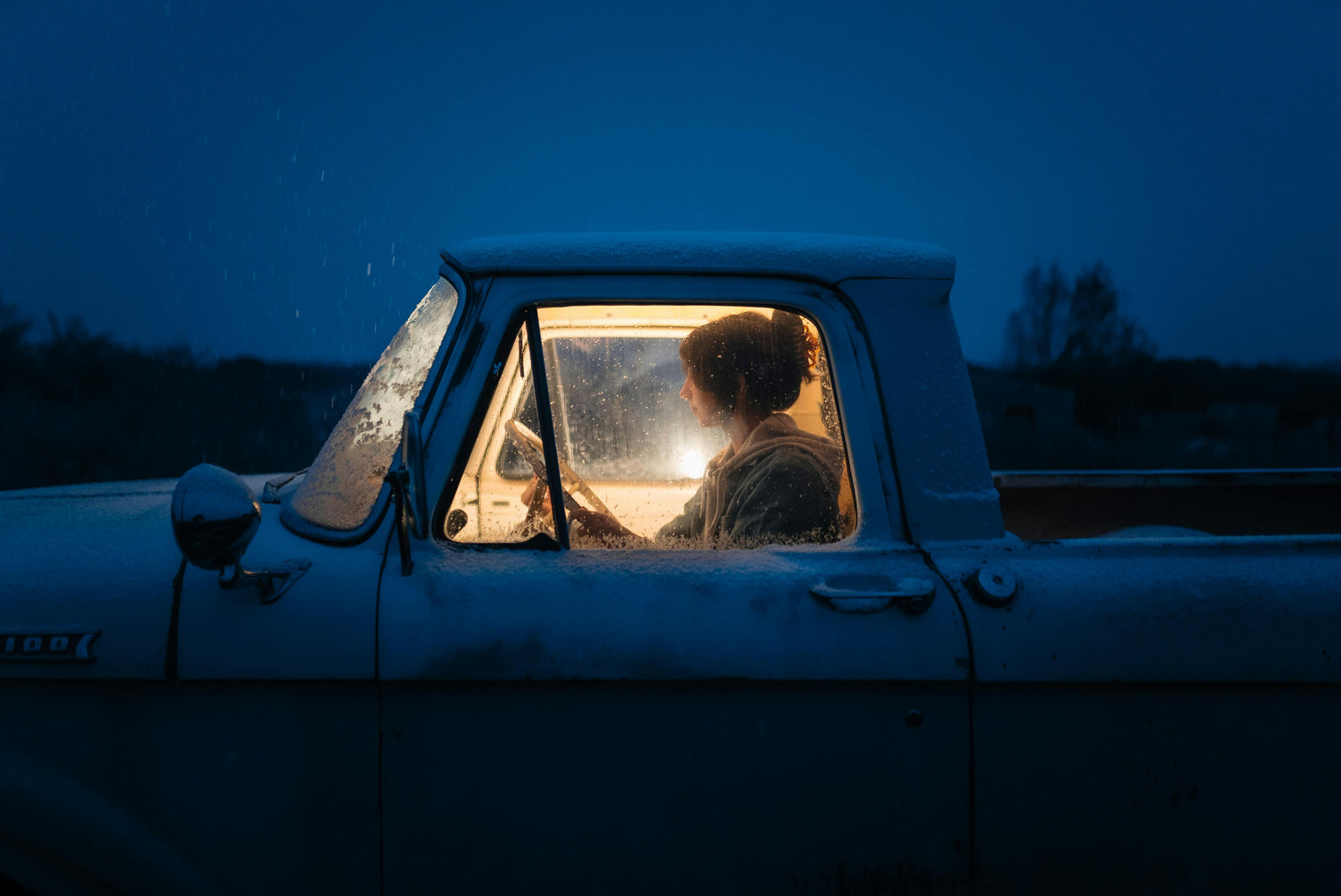 Young Woman alone at night, Siting in a Pickup truck, with a stalled battery